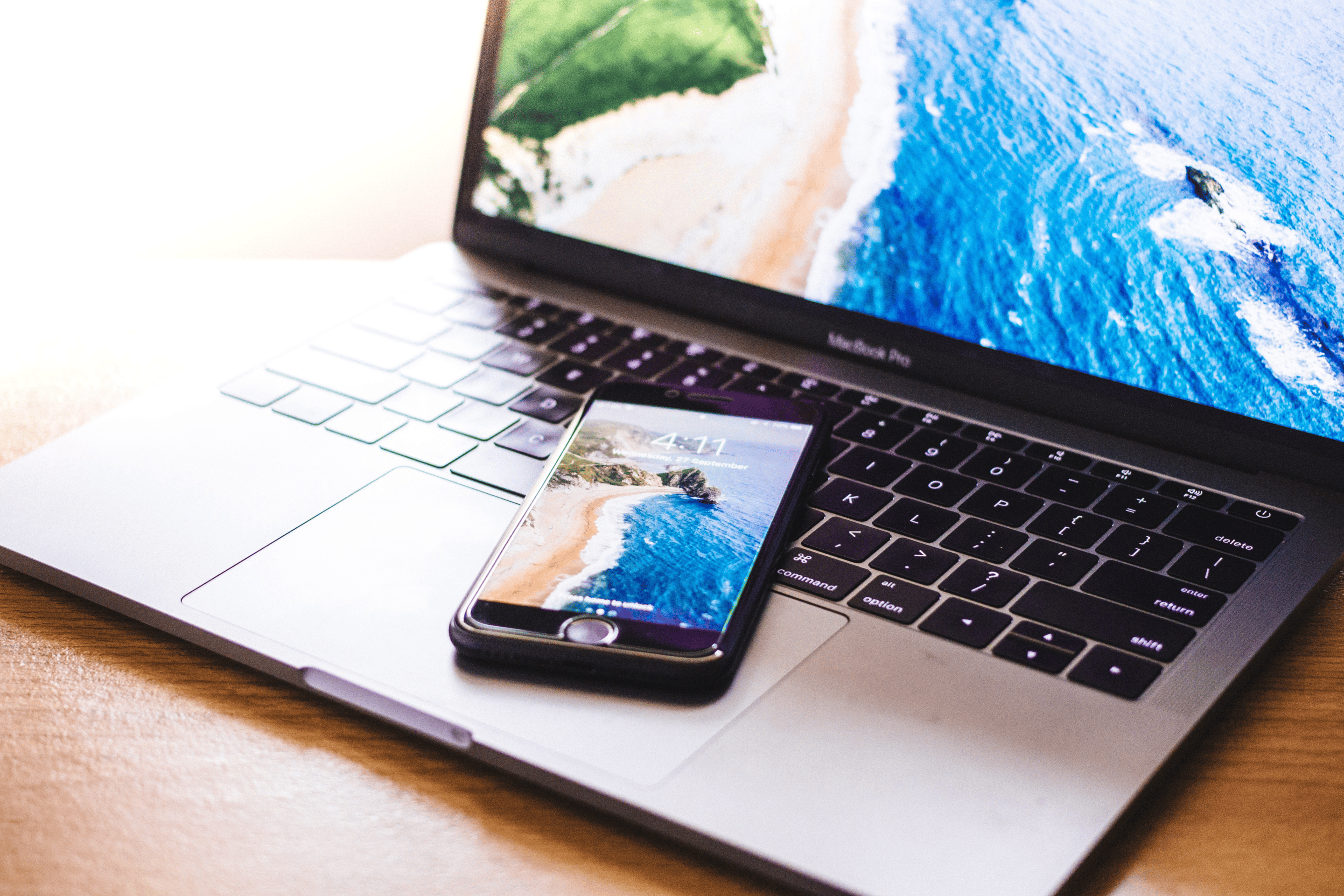 ordinateur et téléphone portable avec photos de plage en fond d'écran
